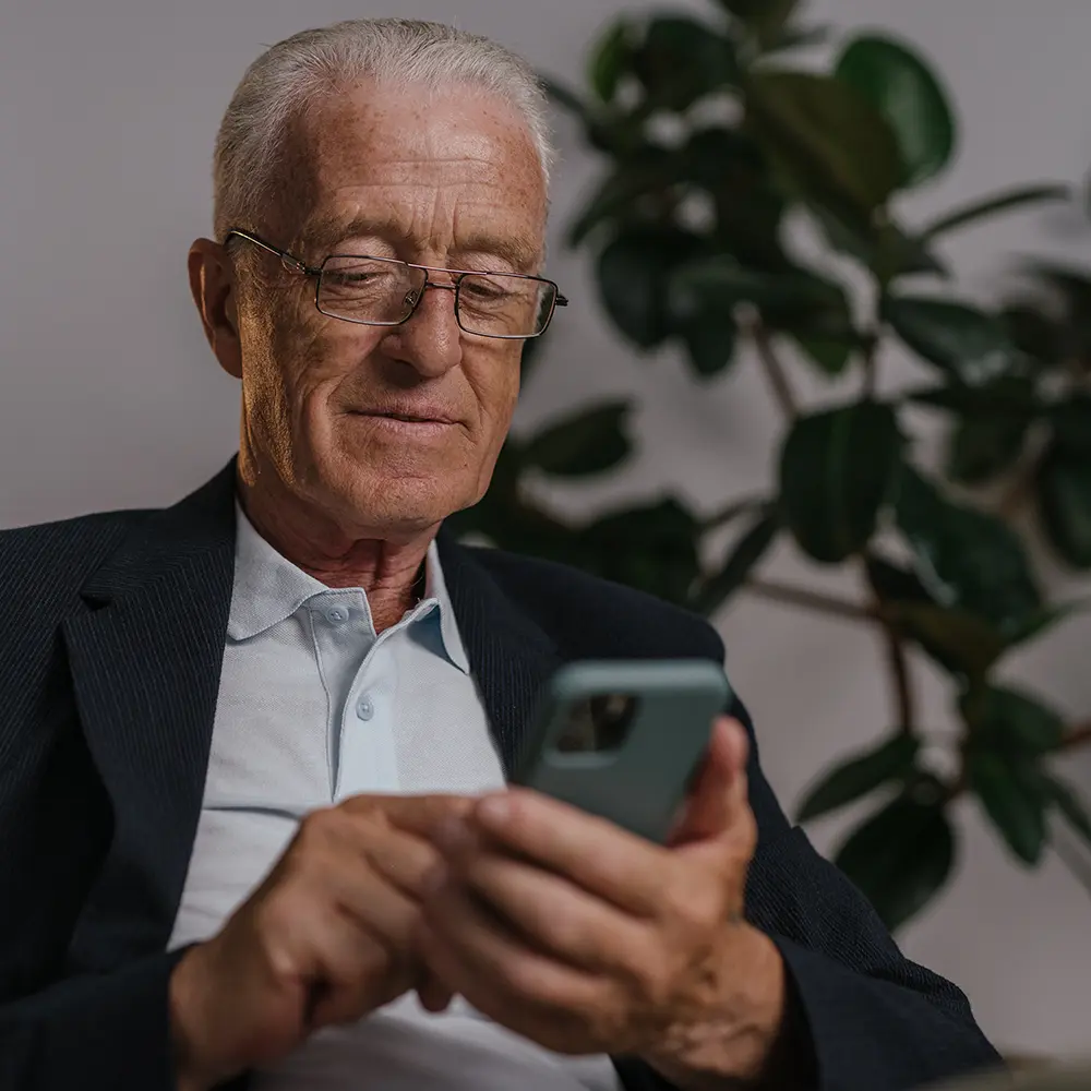 Types of extended audience members for Dial-a-Podcast clients including an elderly man in black suit wearing eyeglasses while using his mobile phone